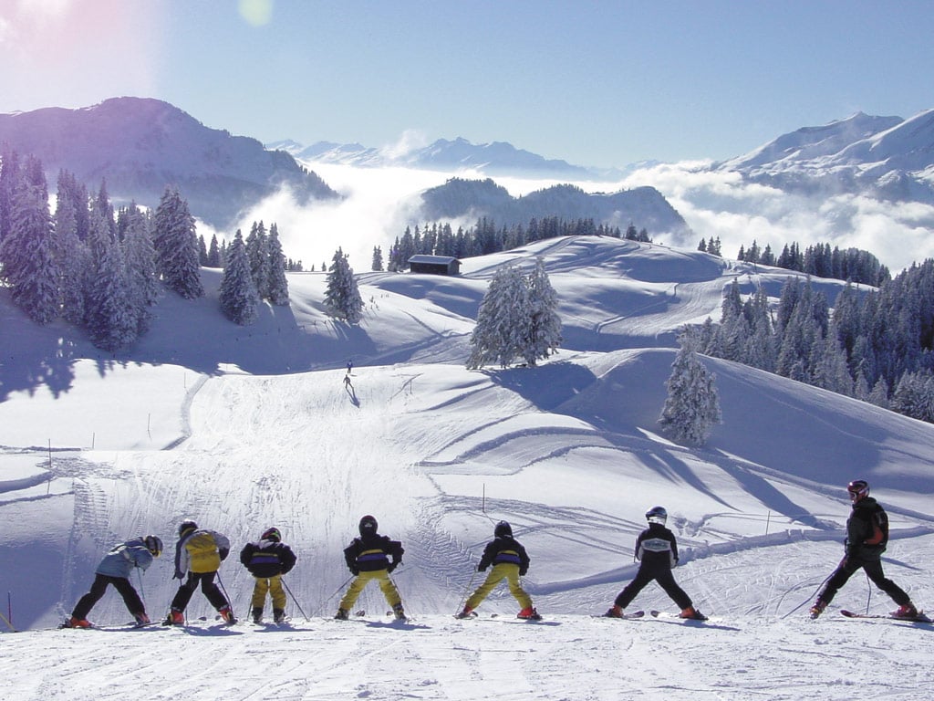 Grüsch Danusa in Switzerland - a group of people skiing down a mountain.