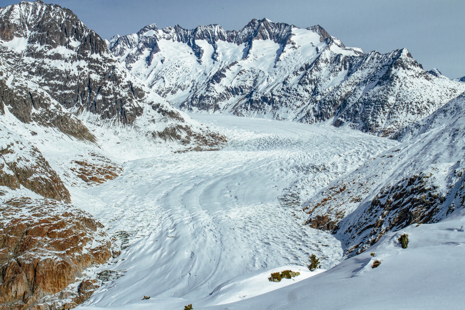 Aletsch Arena in Switzerland - a person skiing down a snow covered mountain.
