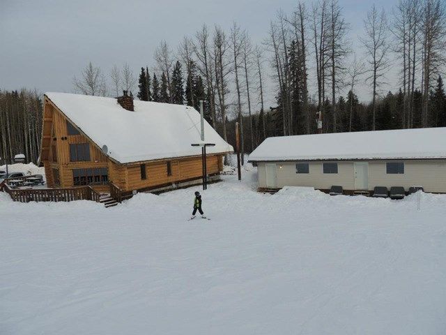 A winter sports scene at Spring Lake Ski Hill in Northern Alberta, Canada. Features a bustling winter sports centre, a ski resort with lively slopes, and a cozy challet and lodge.