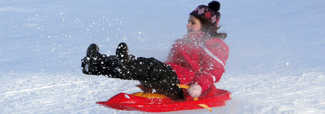 Passo Penice in Italy - a young girl riding a snow sler in the snow.