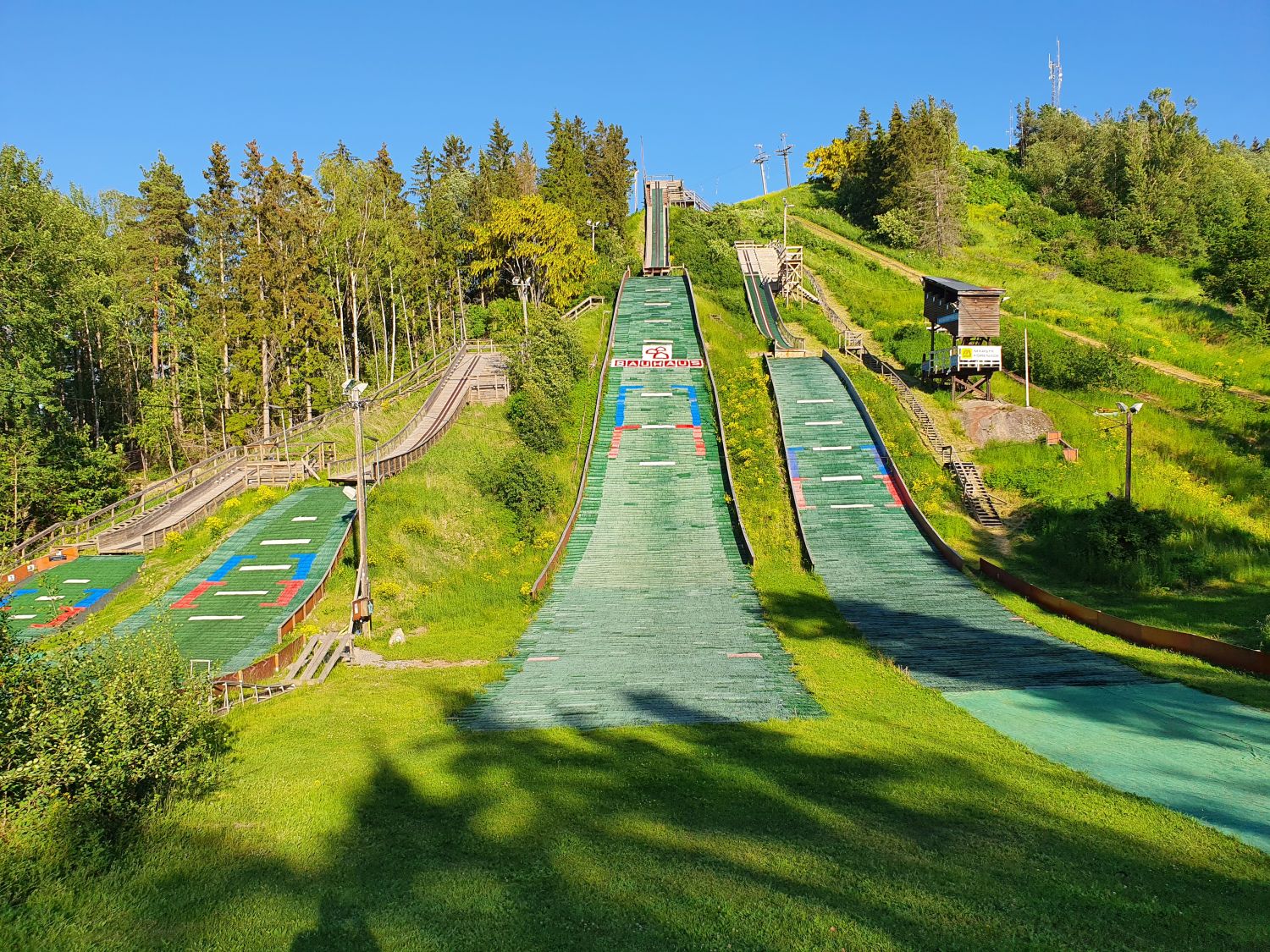 Väsjöbacken – Sollentuna in Sweden - a green hill with a ski lift going down it.