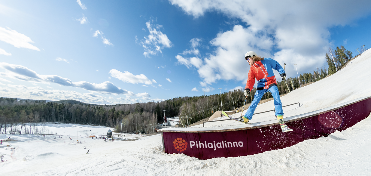 Mustavuori – Tampere in Finland - a man riding a snowboard down a snow covered slope.