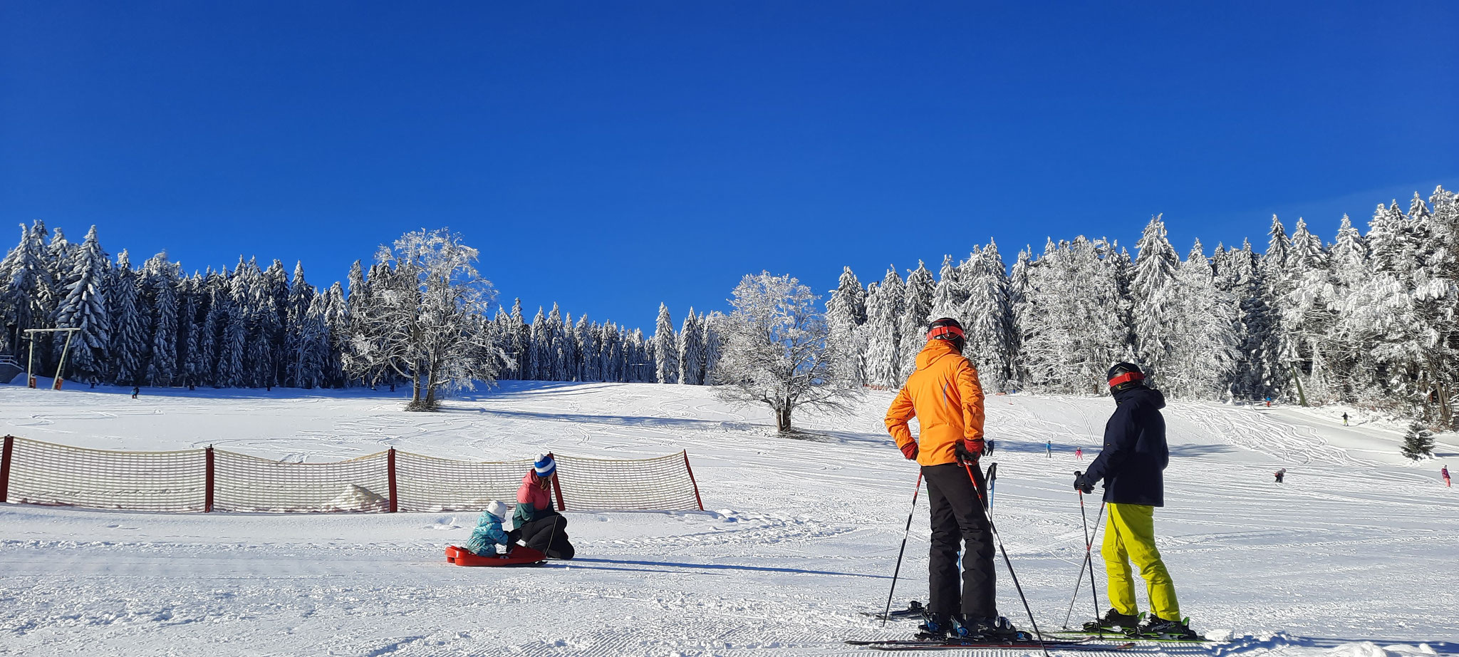 Viehberg – Sandl in Austria - a couple of people standing on top of a snow covered slope.