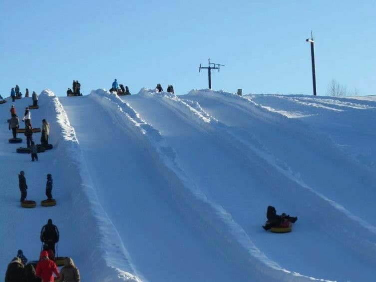 Parc de l'Île Melville – Val Mauricie in Canada - a group of people riding down a snow covered slope.