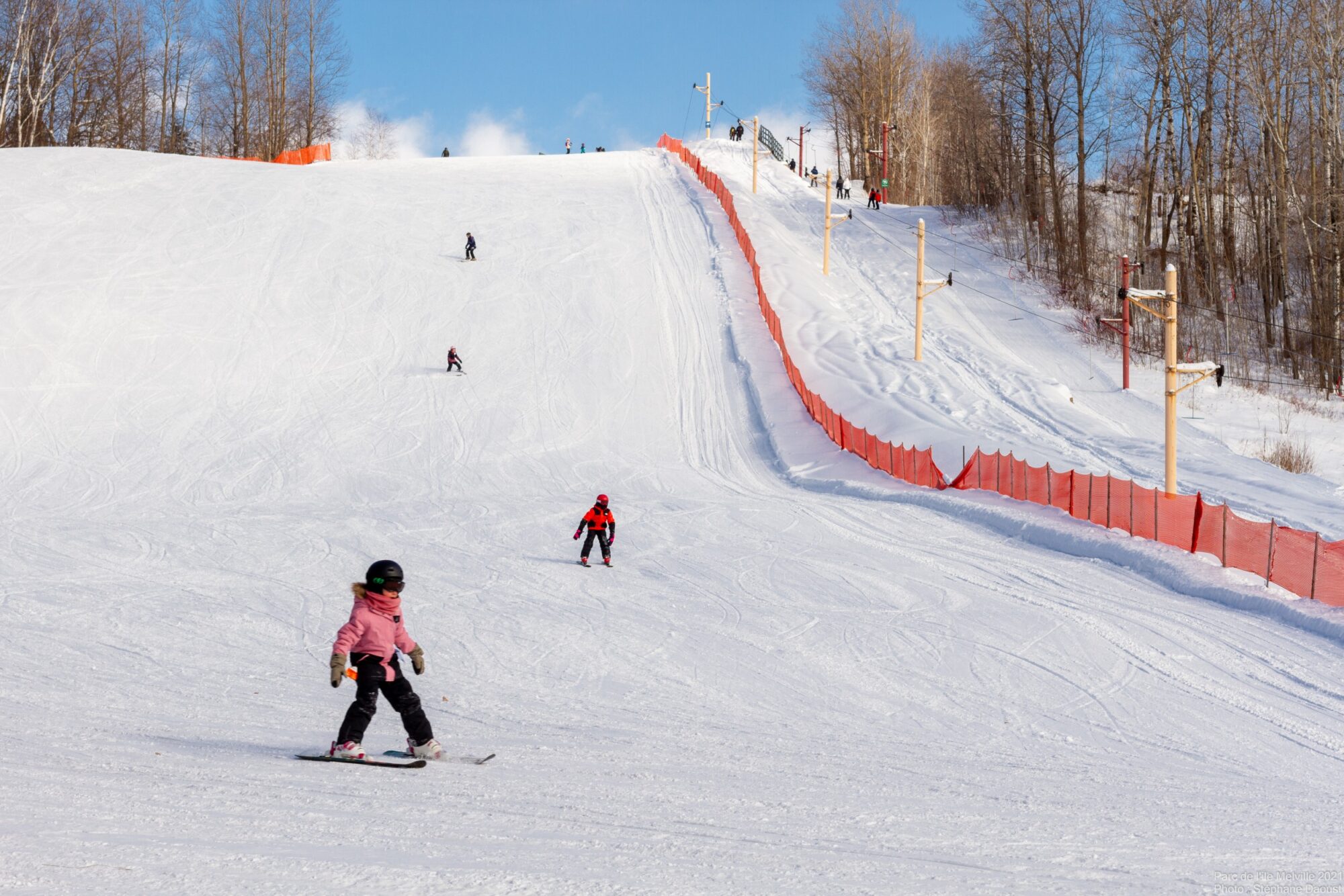 Winter scene at Parc de l'Île Melville – Val Mauricie in Quebec, Canada, featuring a skier taking to the slopes at a ski resort.