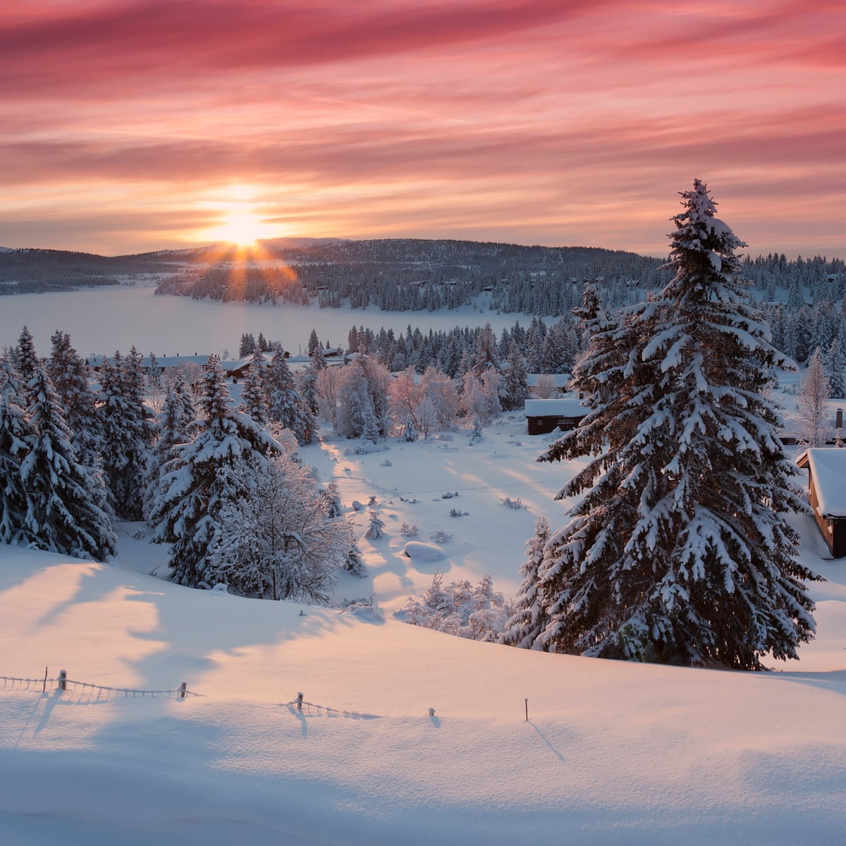 Budor in Norway - the sun is setting over a snowy landscape.