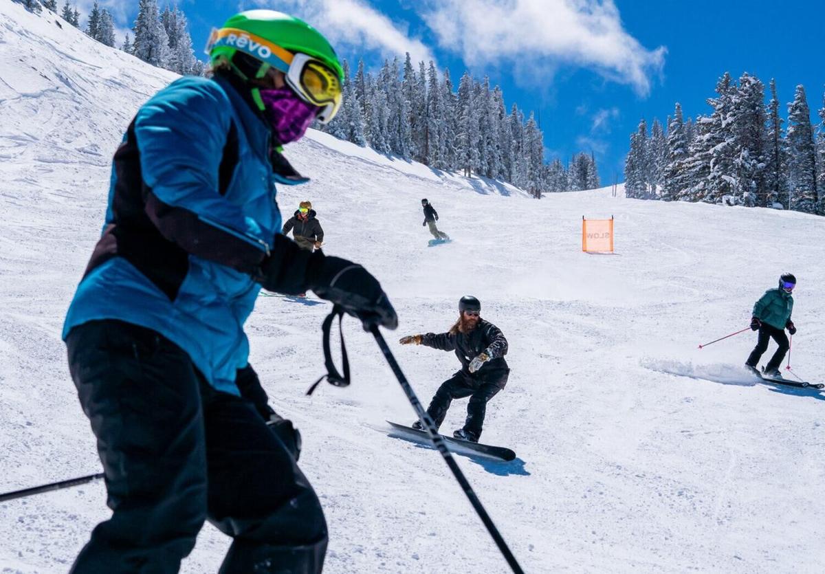 Taos in USA - a group of people skiing down a snow covered mountain.