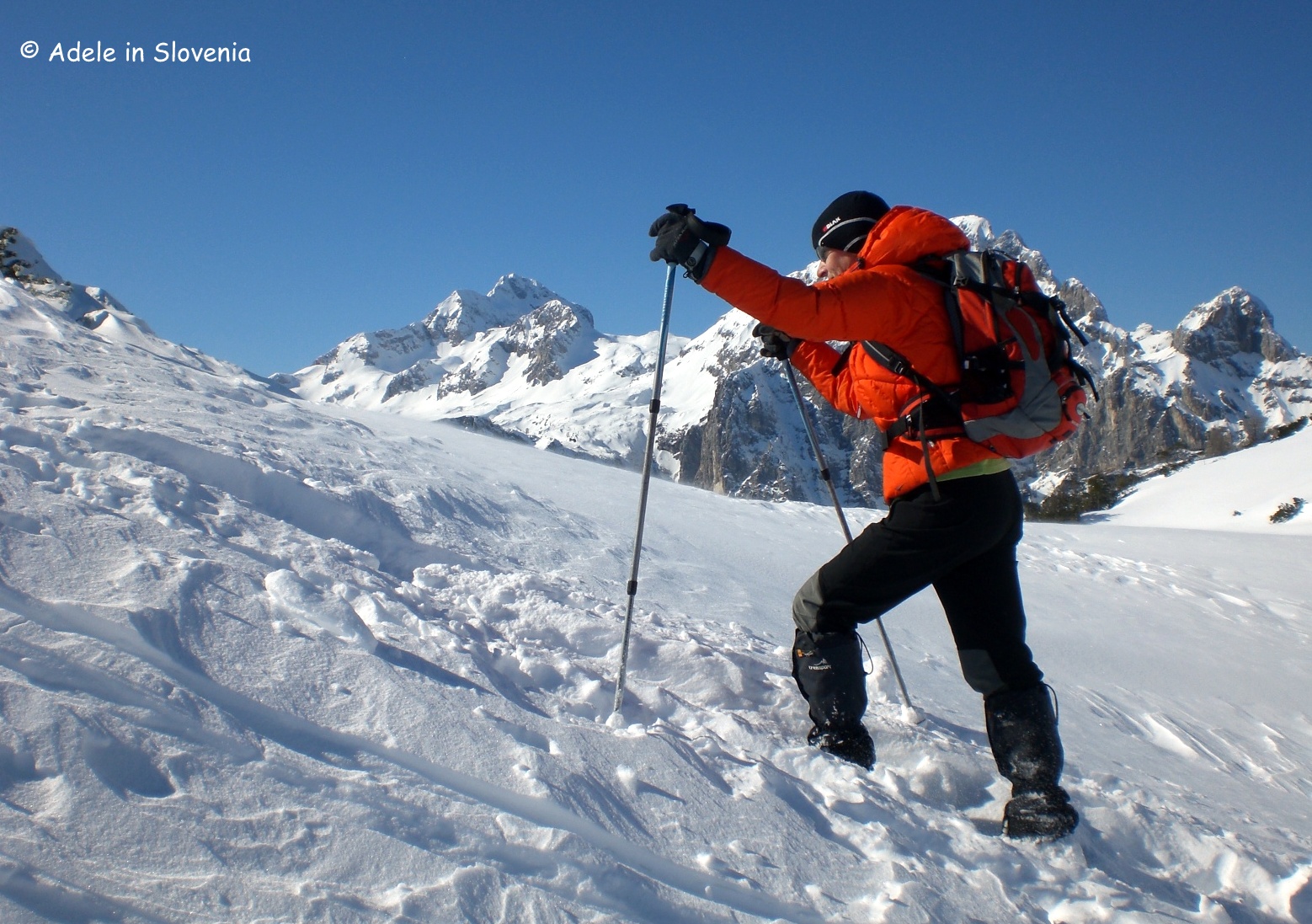 Senožeta in Slovenia - a man in an orange jacket skiing down a snowy slope.