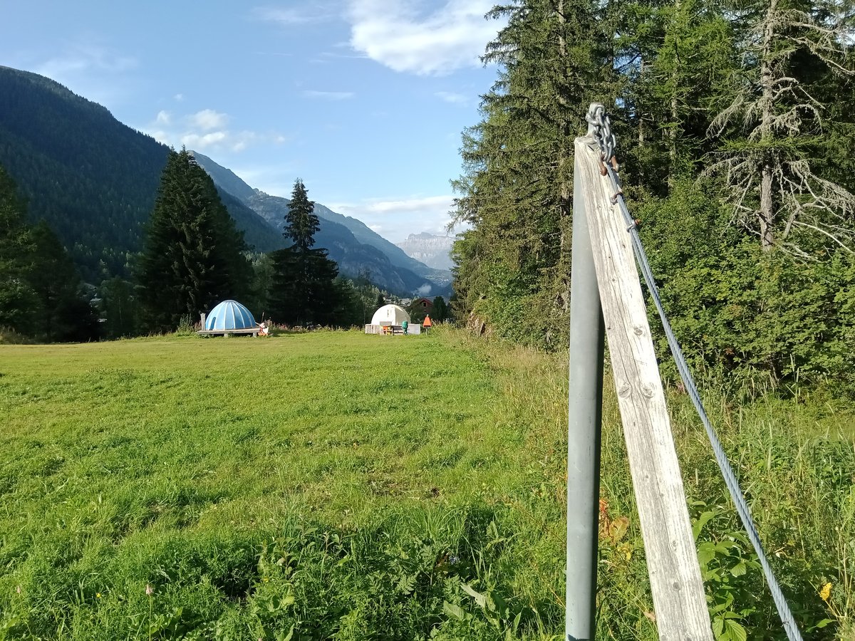 La Poya – Vallorcine in France - a field with a fence and mountains in the background.