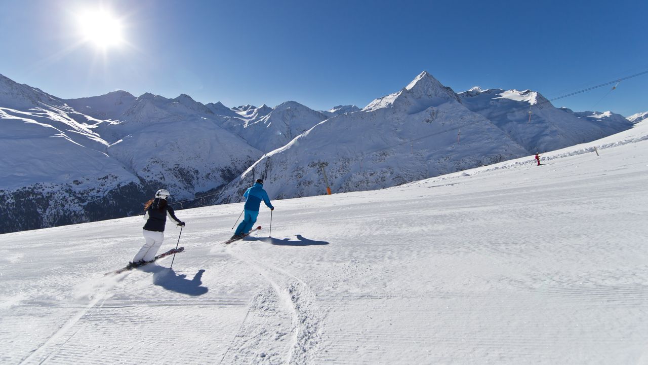 Vent in Austria - two people skiing down a snow covered mountain.