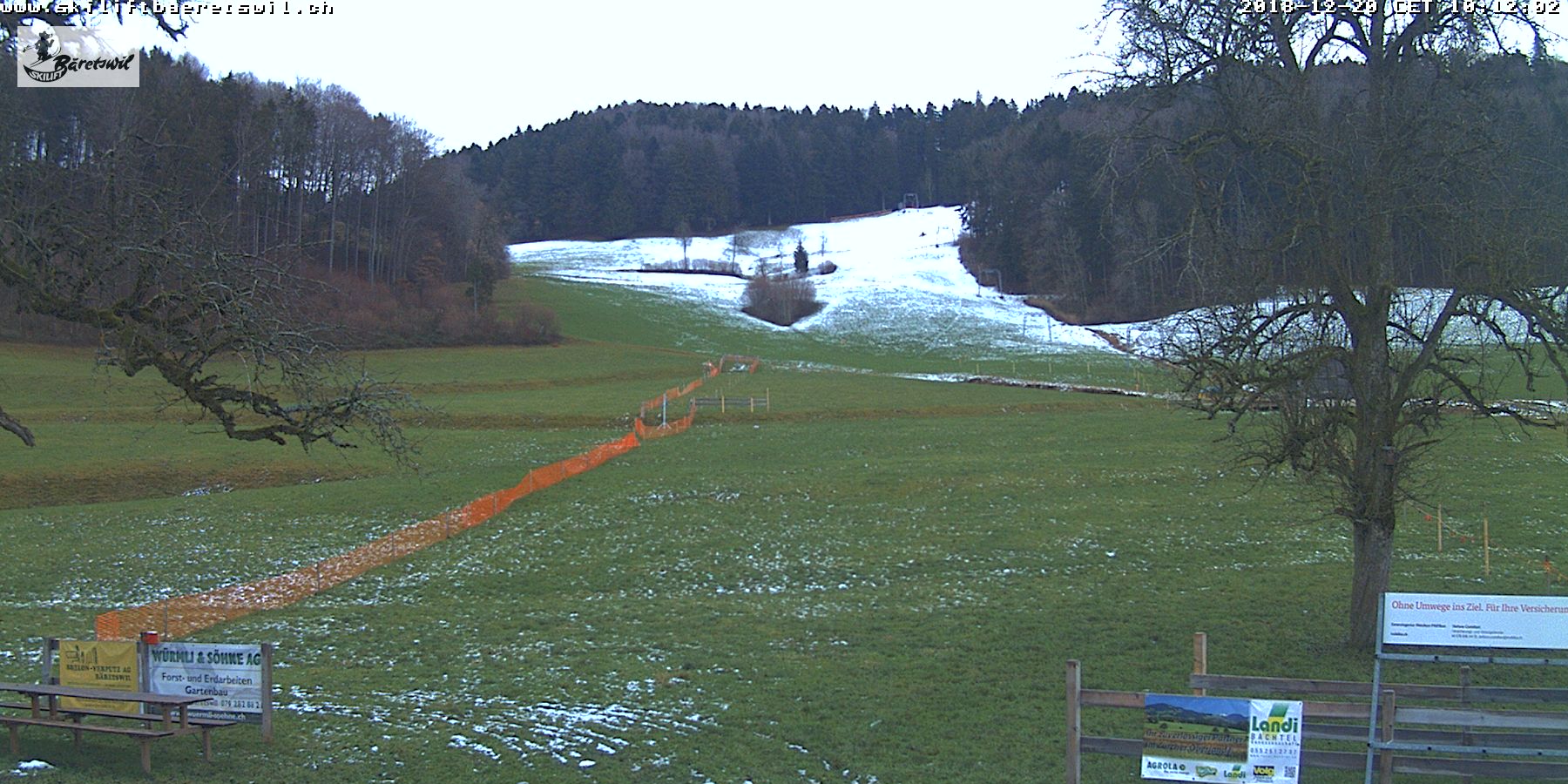 Ghöch in Switzerland - a field with snow on the ground and trees.