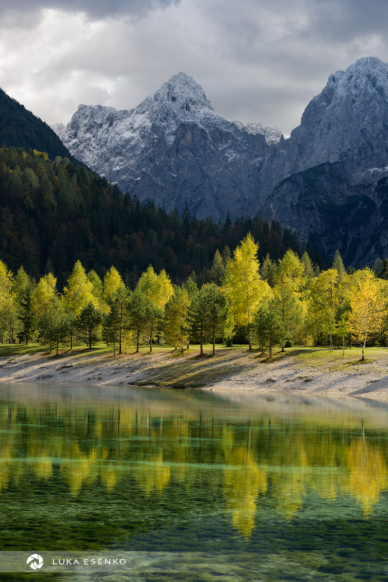 Jalovec in Czech Republic - a lake with trees and mountains in the background.