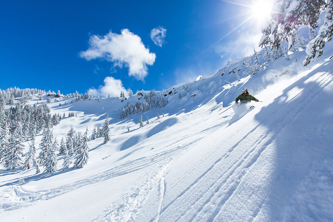 Sierra at Tahoe in USA - a person riding a snowboard down a snowy slope.