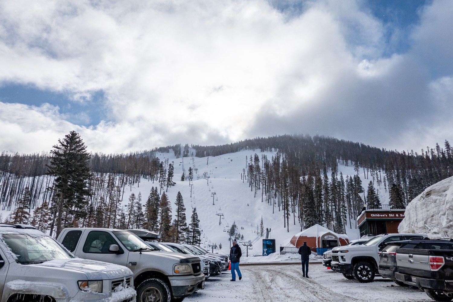 Sierra at Tahoe in USA - a group of cars parked on a snow covered road.