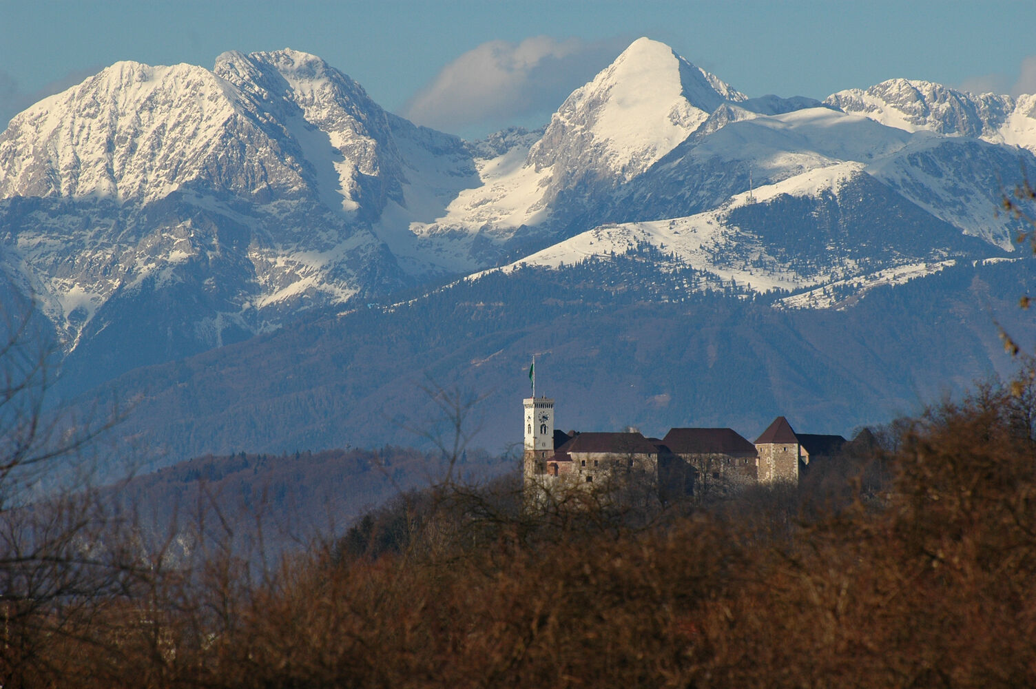Dole Pri Litiji in Slovenia - a church in front of a snowy mountain range.