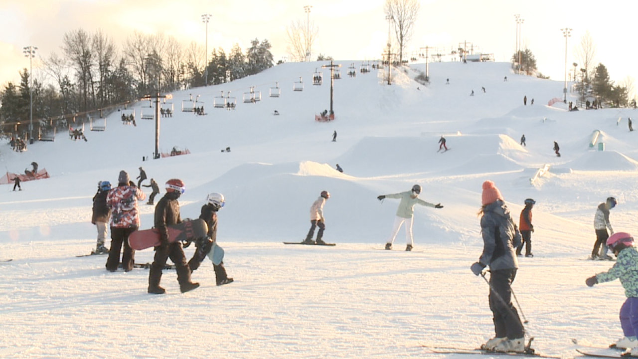 Mulligan's Hollow Ski Bowl in USA - a group of people skiing down a snowy hill.