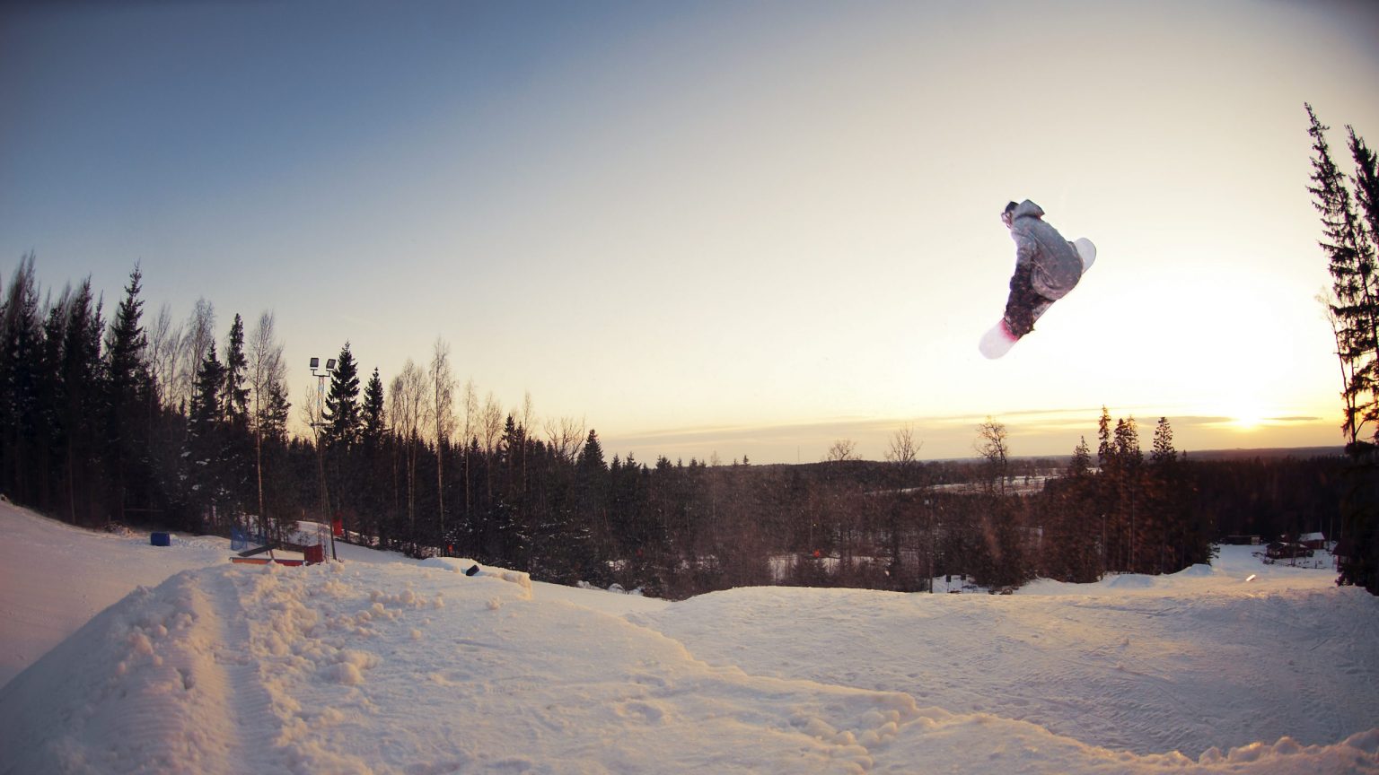 Hanaslöv in Sweden - a person jumping in the air on a snowboard.