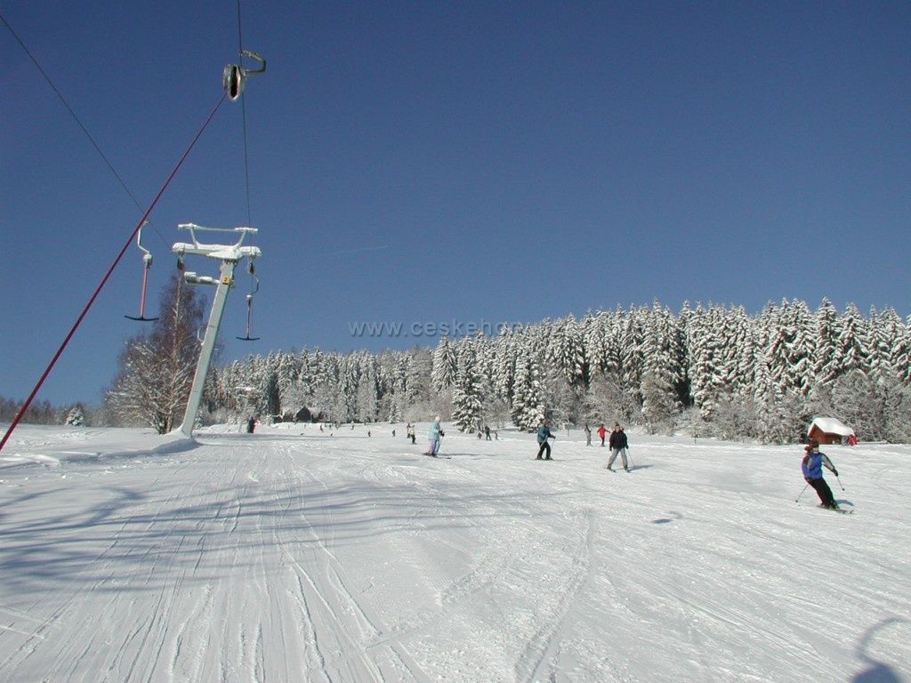 Luisino Údolí in Czech Republic - a group of people skiing down a snowy slope.