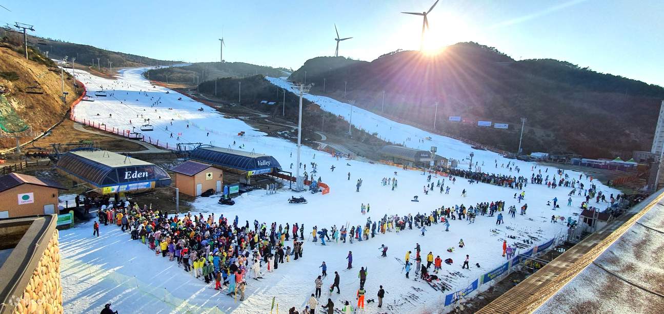 Eden Valley Resort in South Korea - a group of people standing on a snow covered slope.