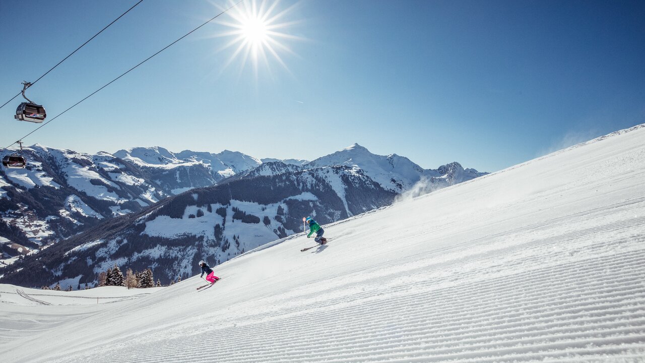 Juwel Alpbachtal Wildschönau in Austria - a person riding a ski board down a snow covered slope.
