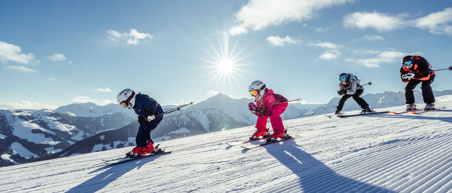 Juwel Alpbachtal Wildschönau in Austria - a group of people skiing down a snowy slope.