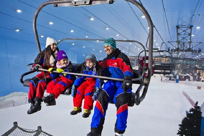 A family enjoying skiing at Ski Egypt resort, utilizing a ski lift amidst a winter sports scene, with a ski resort challet in the background.