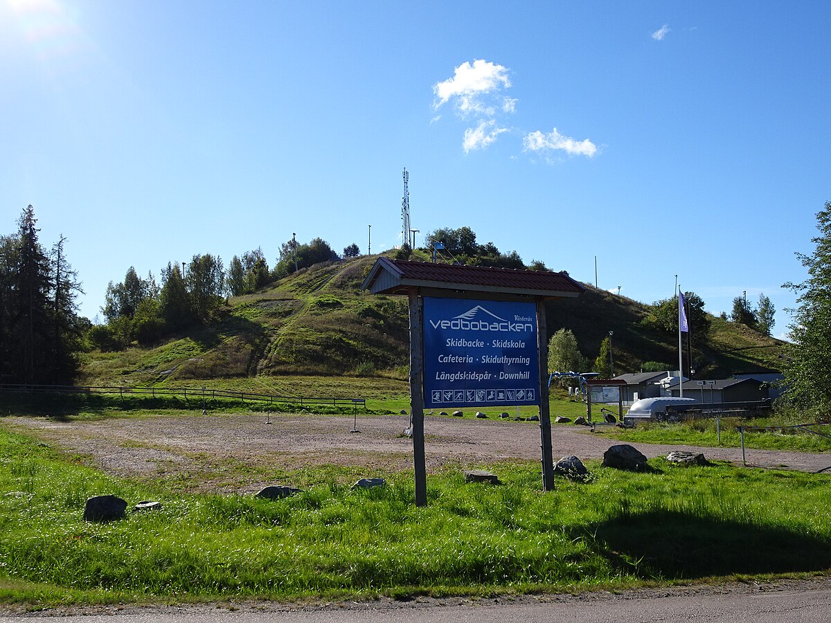 Vedbobacken – Västerås in Sweden - a blue sign sitting on the side of a road.