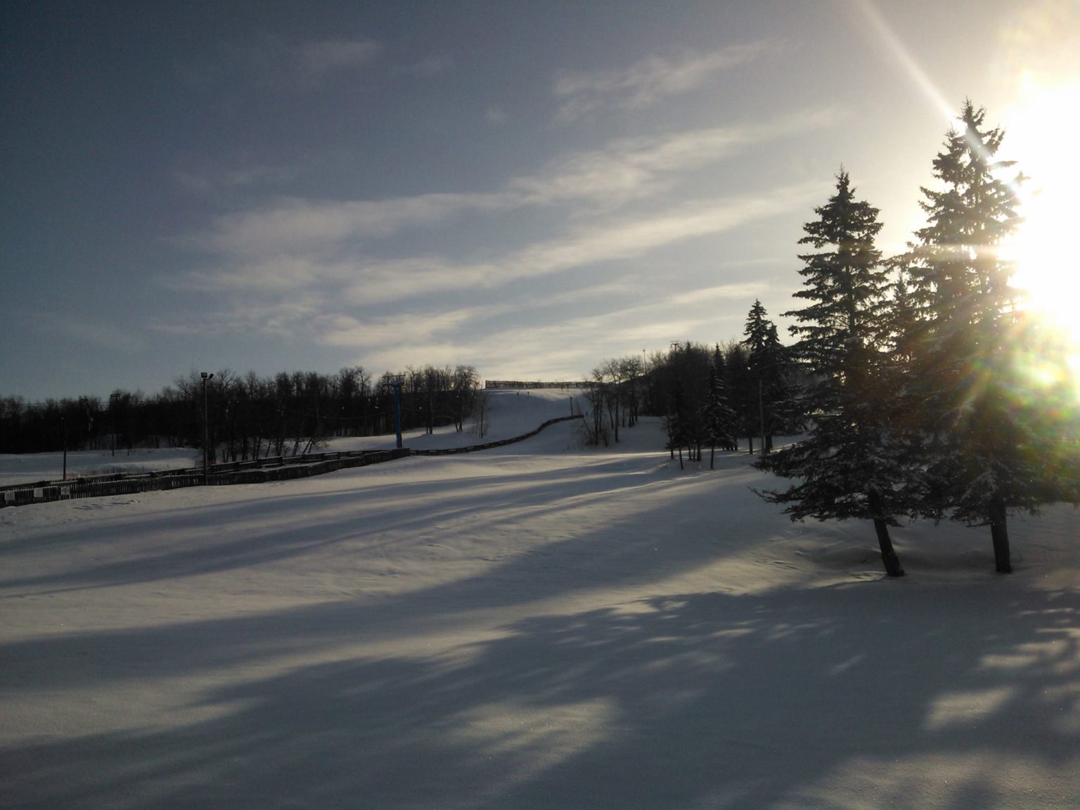 Gwynne Valley in Canada - the sun is shining through the trees in the snow.
