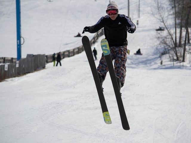A skier skillfully maneuvers down the wintry slopes of Gwynne Valley in Central Alberta, Canada. A beautiful winter sports scene is depicted, showcasing the serene and thrilling atmosphere of the ski resort.
