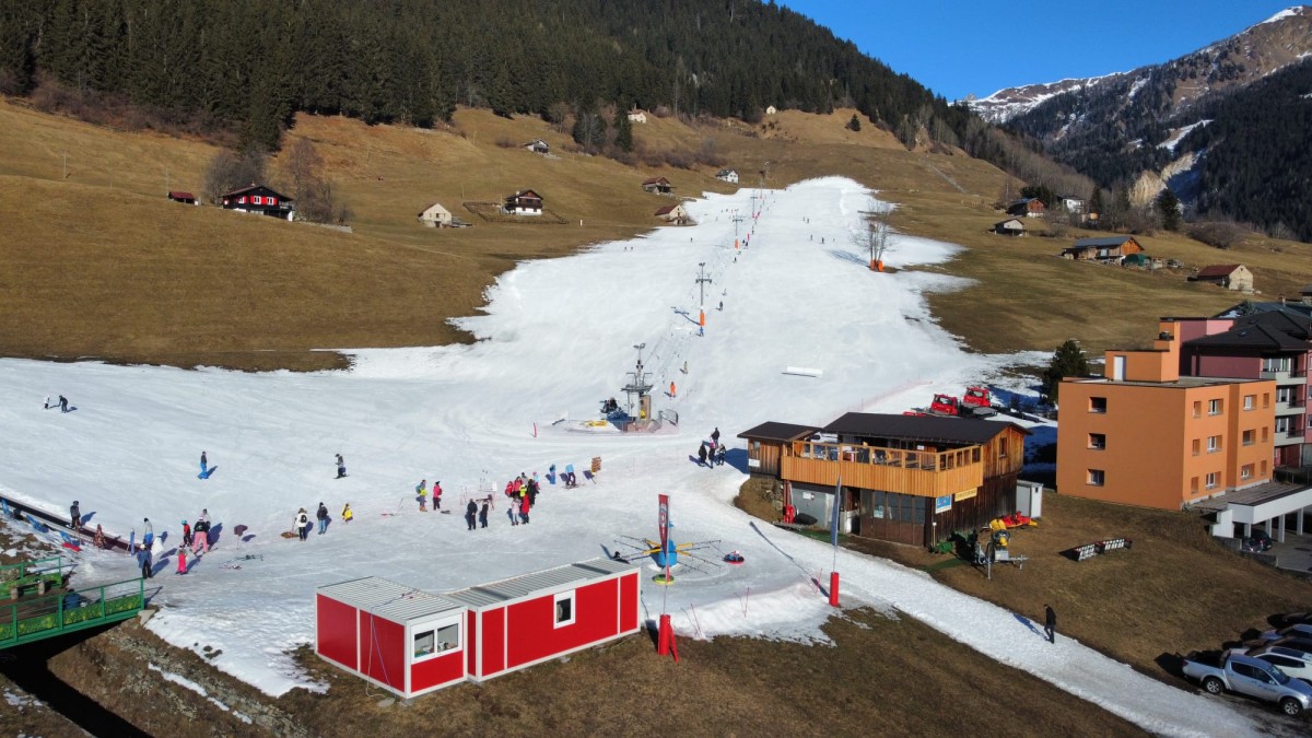 Lüina – Airolo in Switzerland - a group of people skiing down a hill.