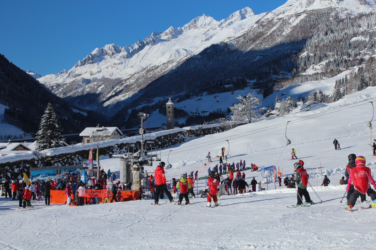 Lüina – Airolo in Switzerland - a group of people skiing down a snow covered slope.