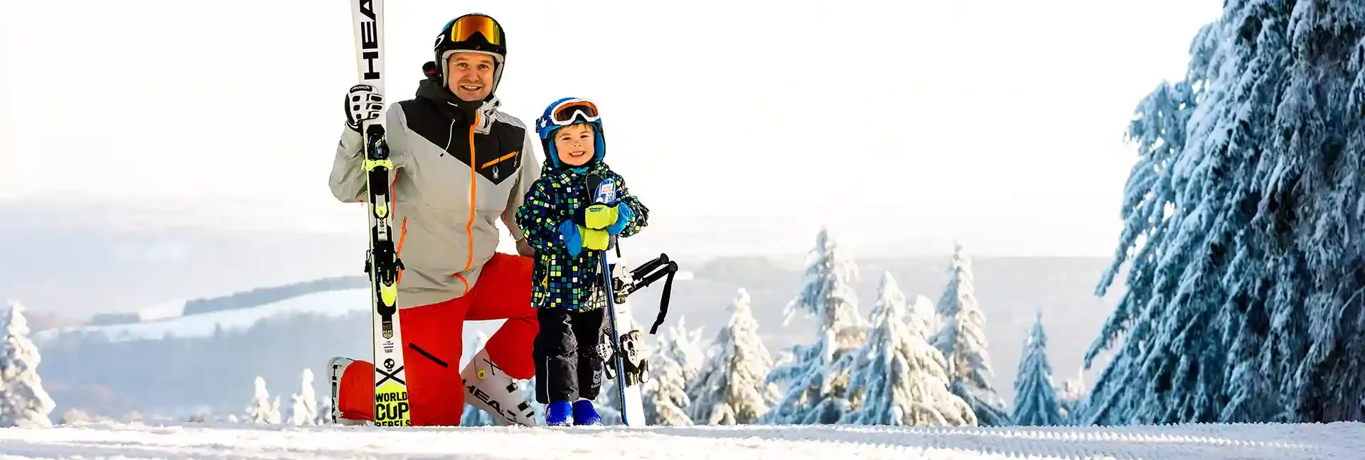 Hoherodskopf – Breungeshainer Hang | ​Rennwiese in Germany - a man and a child are standing in the snow.