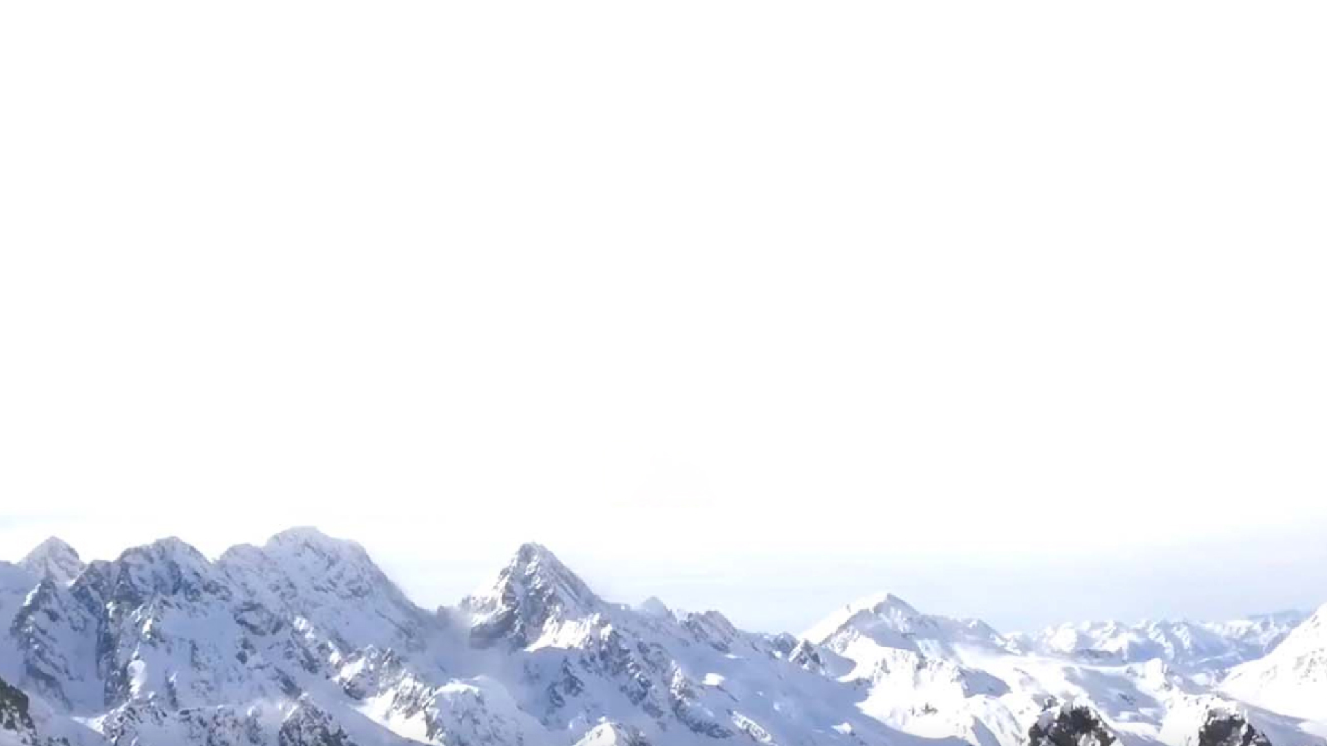 A skier descends a trail at the Ordino Arcalís ski resort in Andorra, contrasting sharply against the grand backdrop of a towering, snow-covered mountain.