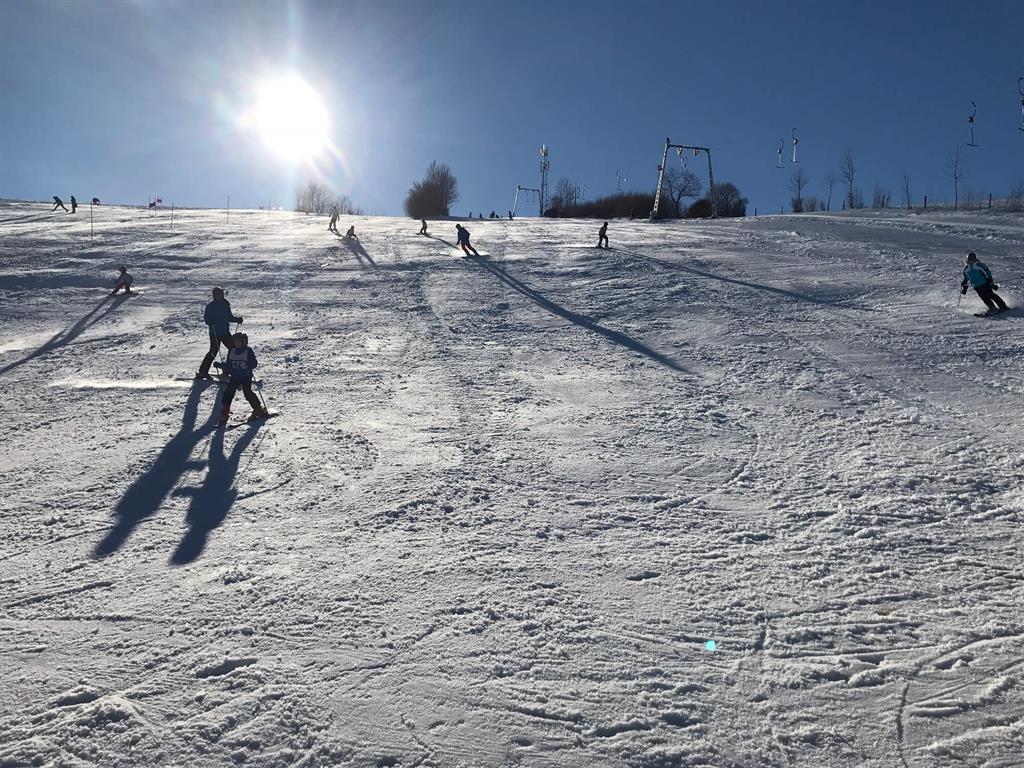 Treffelhausen – Böhmenkirch in Germany - a group of people skiing down a snow covered slope.
