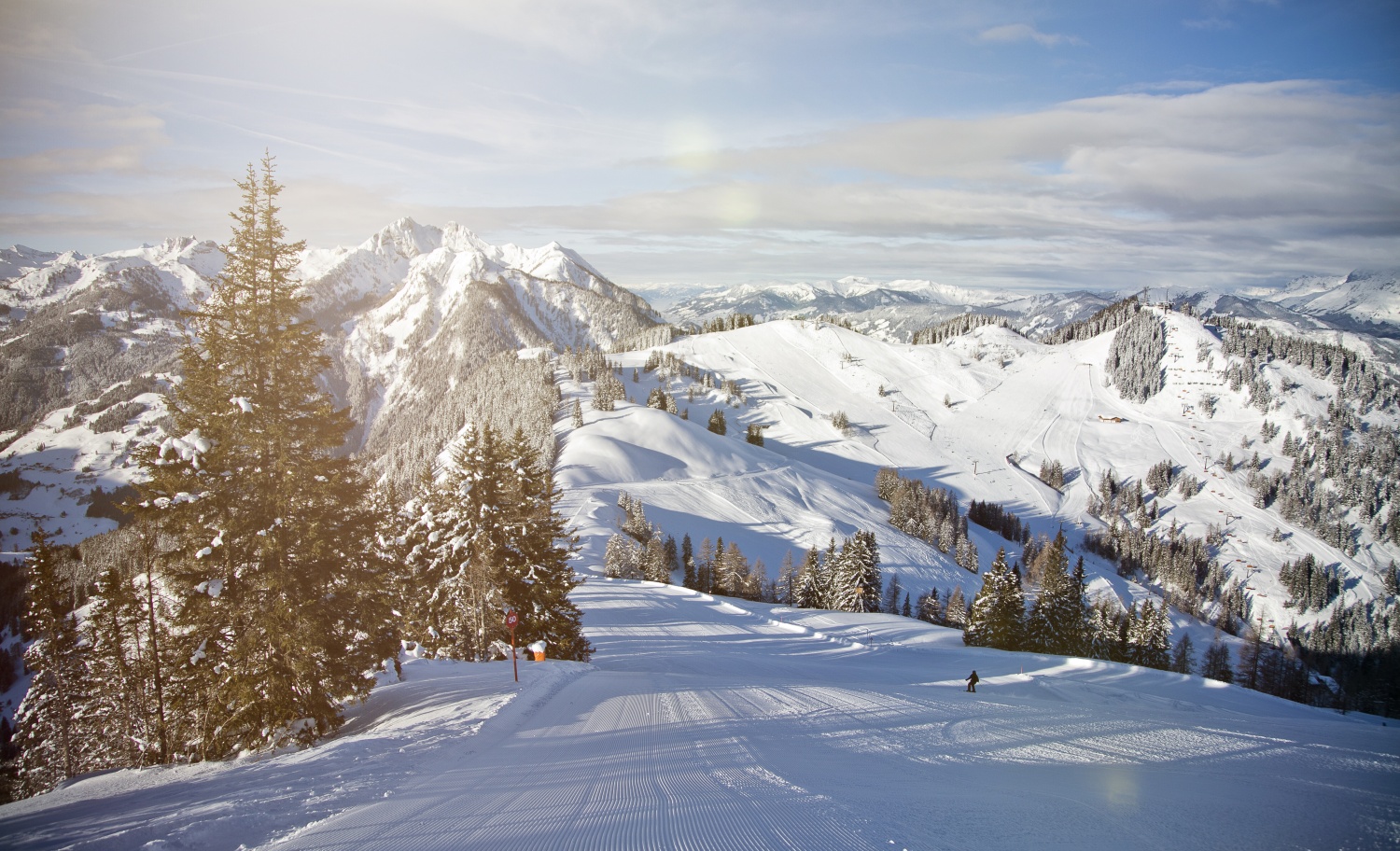 Hahnbaum – St Johann im Pongau in Austria - a person on a snowboard on a mountain.