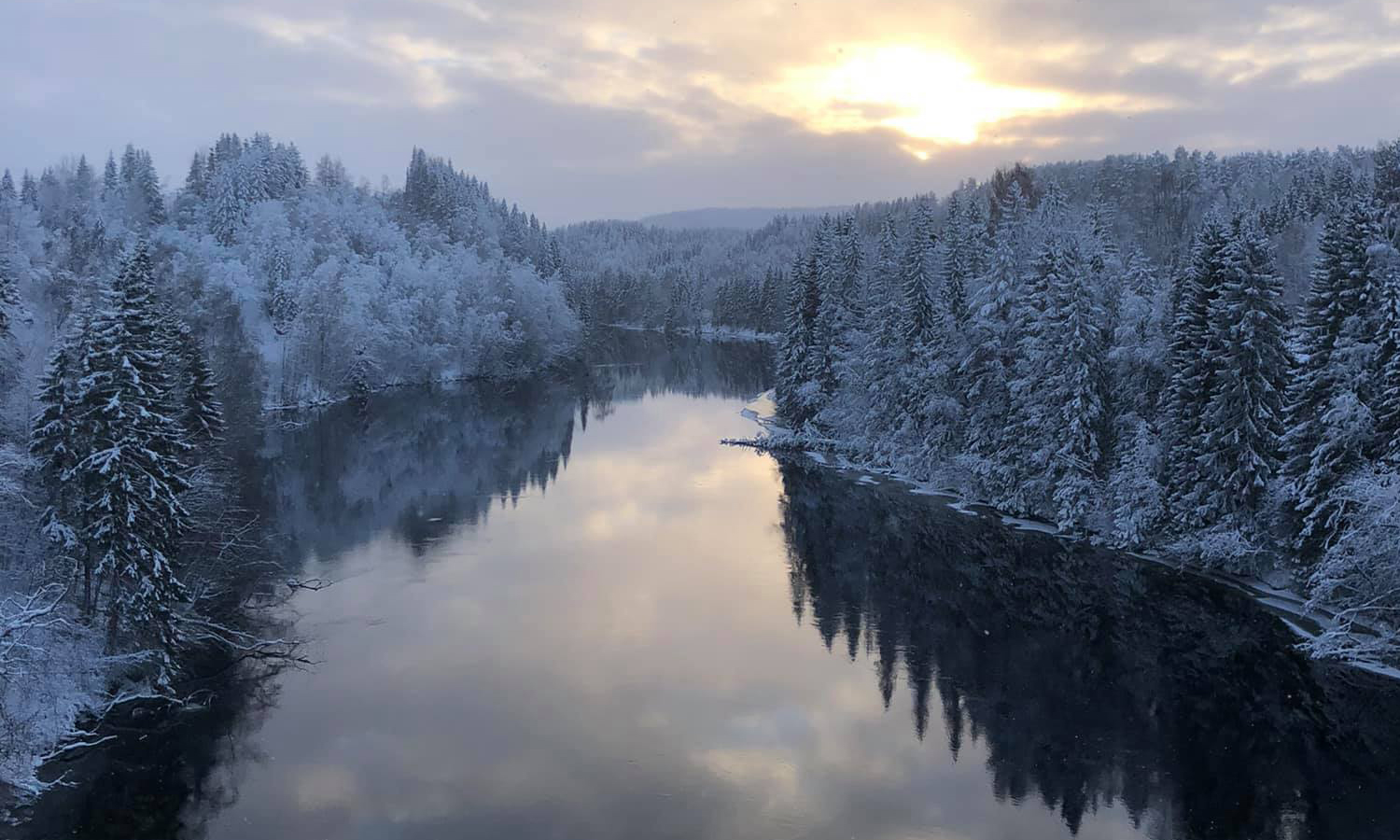 Ramsele in Sweden - a river surrounded by snow covered trees.
