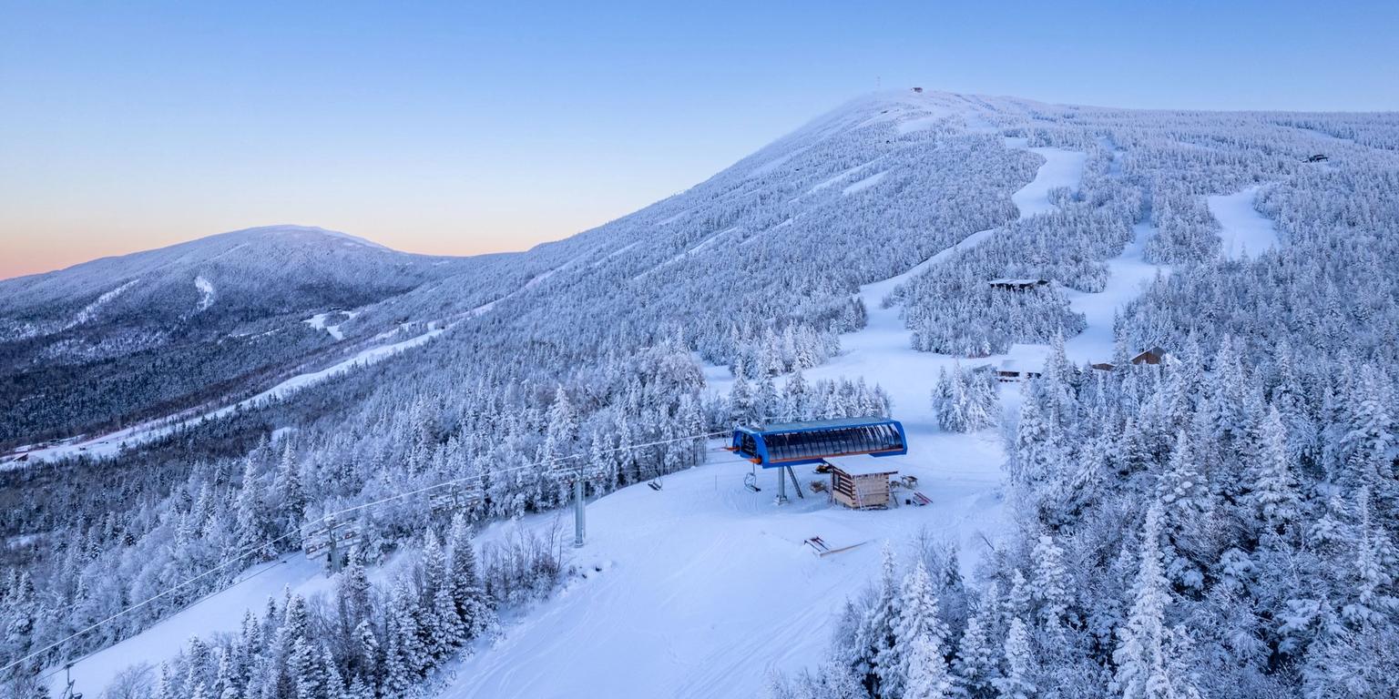 Sugarloaf Mountain in USA: a ski resort surrounded by snow covered trees.