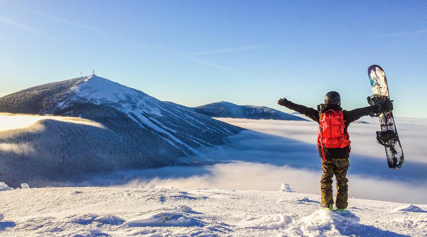 Sugarloaf Mountain in USA - a person standing on top of a snow covered mountain.