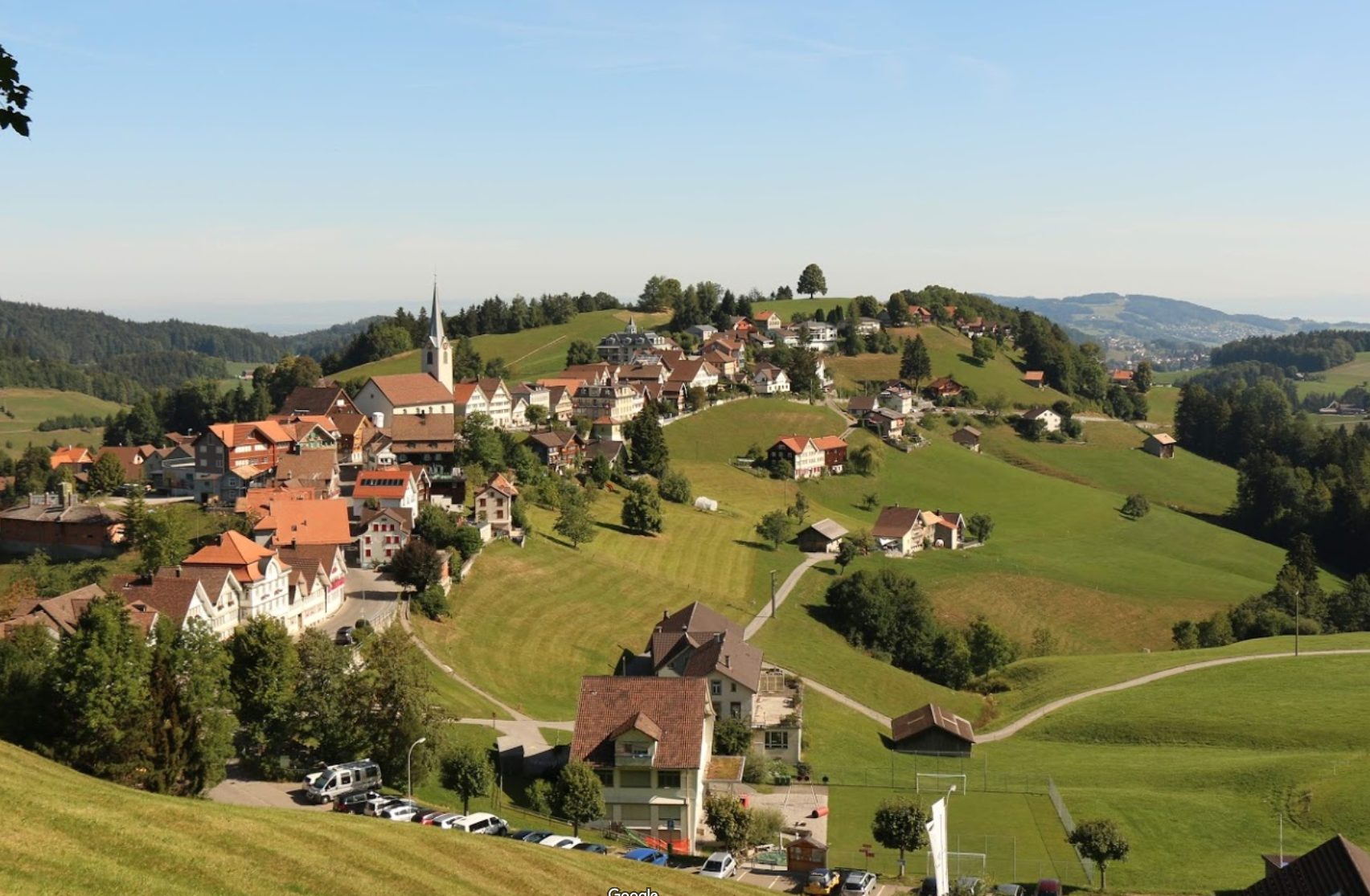 Schwellbrunn in Switzerland - a view of a small town on a hill.