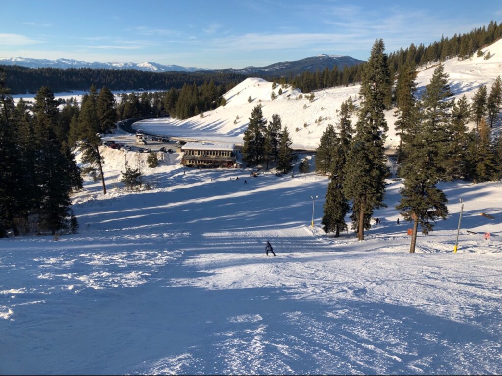 Skier enjoying a winter day at Little Ski Hill in Idaho. The ski resort, with a functioning ski lift, is blanketed by snow, highlighting the popular winter sports scene.