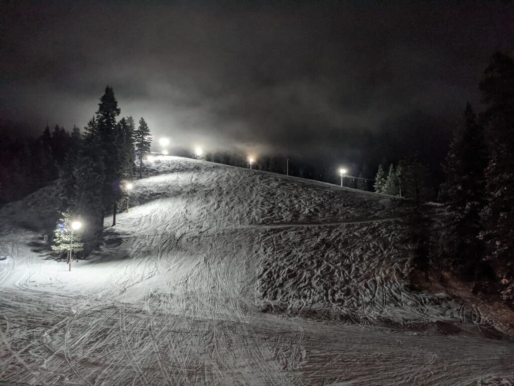 A ski enthusiast exploring the snowy slopes of Little Ski Hill in Idaho. The age-old ski lift carries more adventure-seekers up the picturesque, snow-blanketed resort.