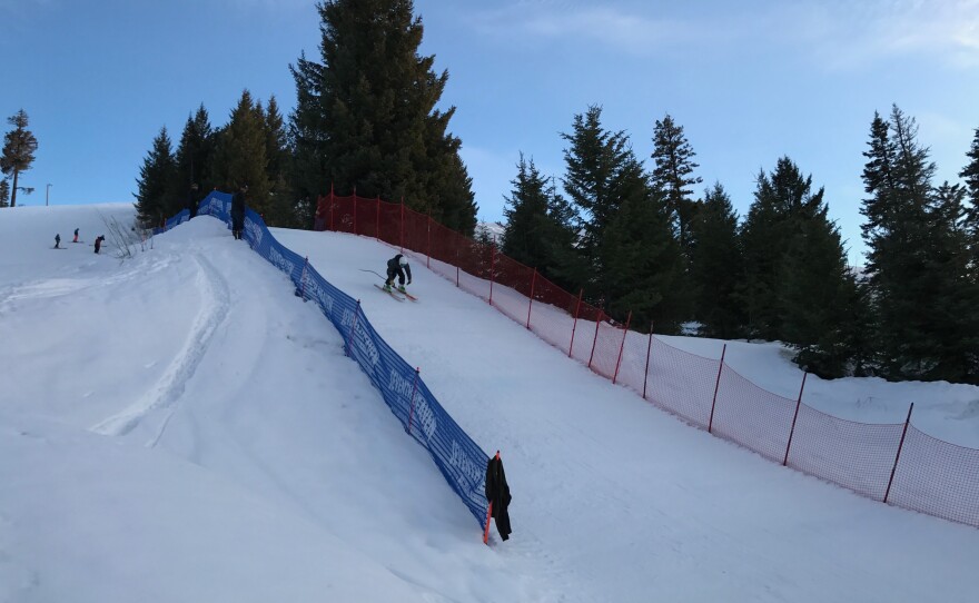 A skier enjoying a day on the slopes at Little Ski Hill, a winter sports centre in Idaho, USA. The scene includes a cozy challet surrounded by a picturesque winter landscape.