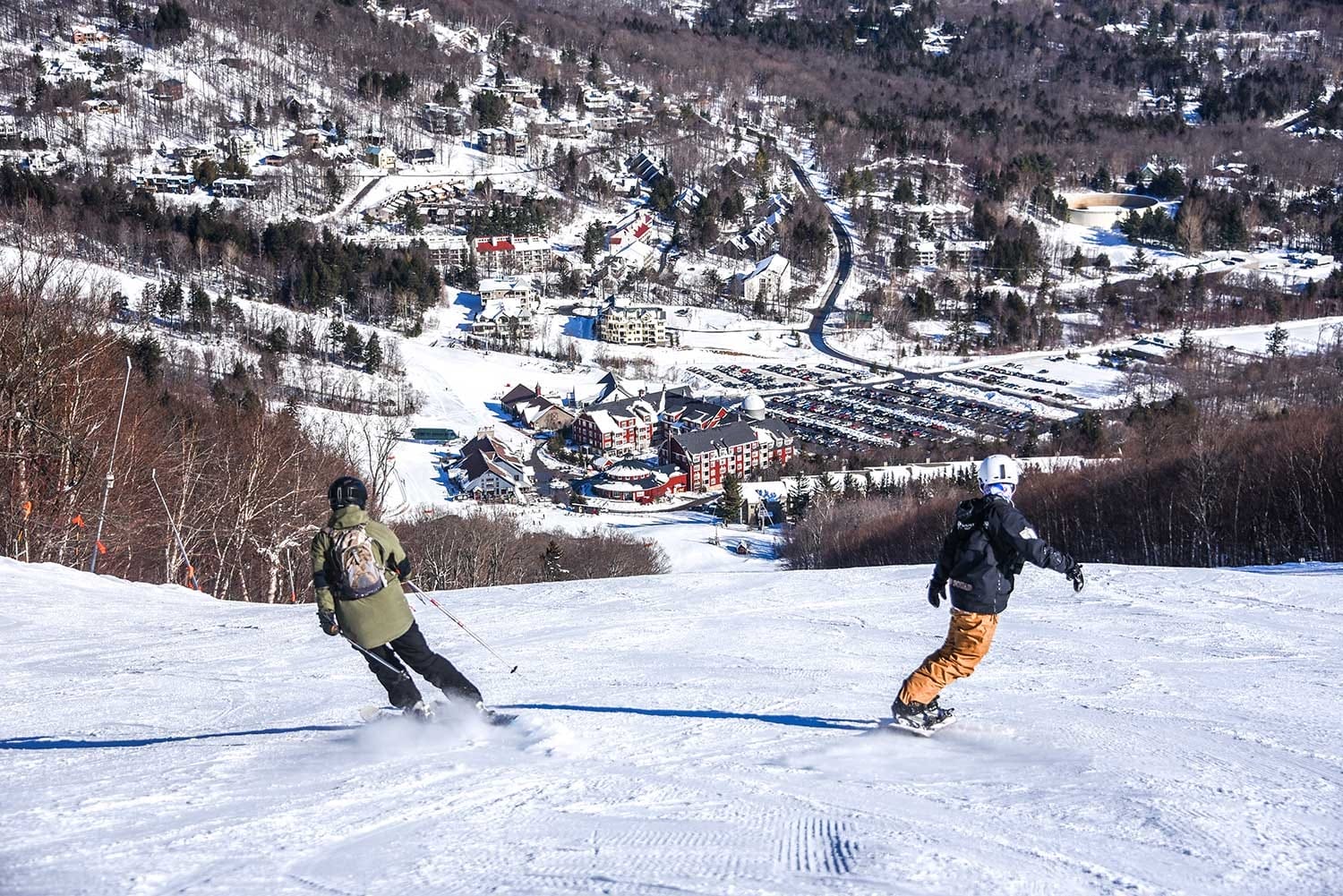 Sugarbush Resort in USA - a couple of people skiing down a hill.
