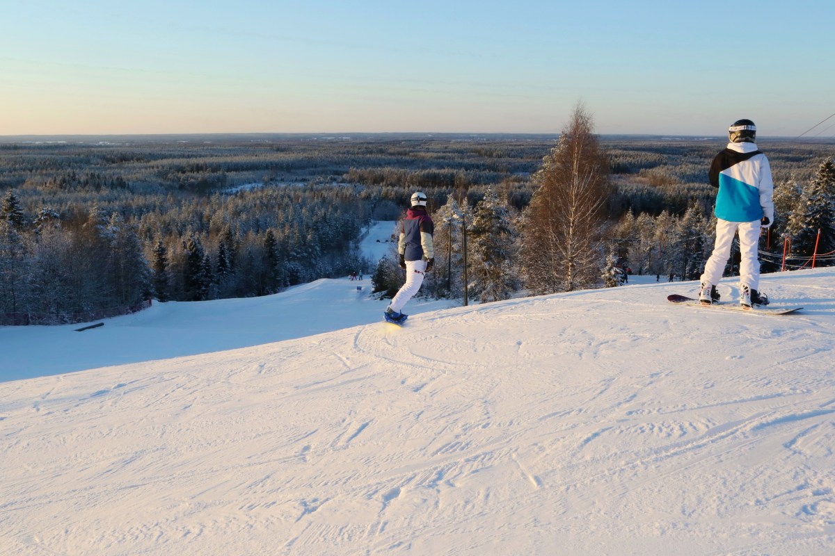 Parra in Finland - two people are skiing down a snowy hill.