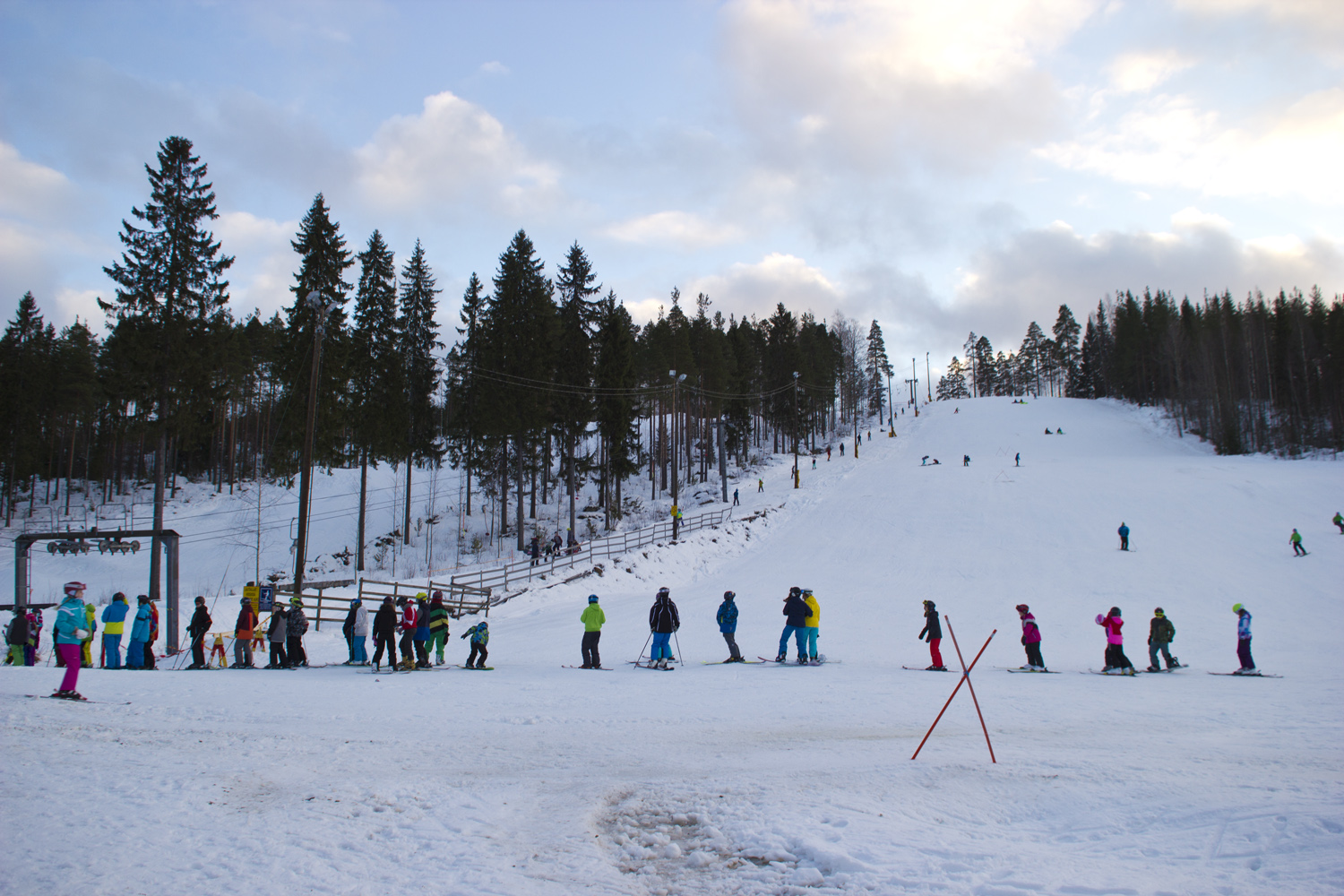 Äänemäki – Äänekoski in Finland - a group of people skiing down a snowy hill.