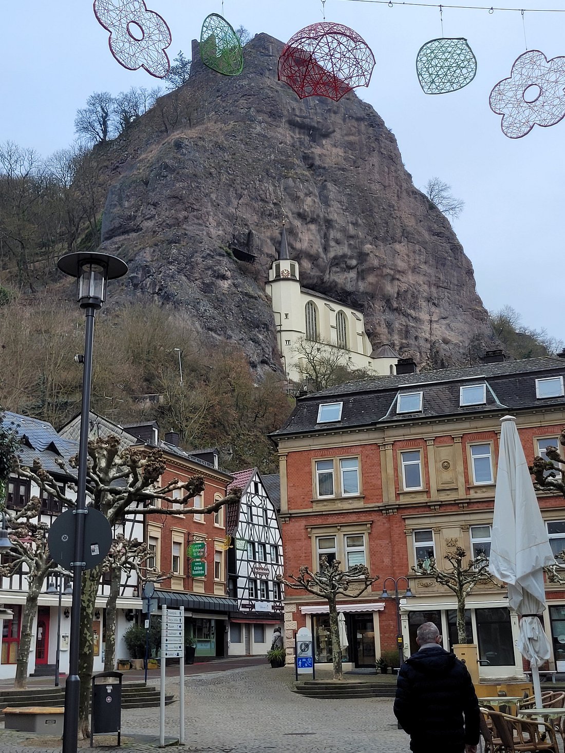 Freizeitzentrum in Germany - a person walking down a street in front of a mountain.