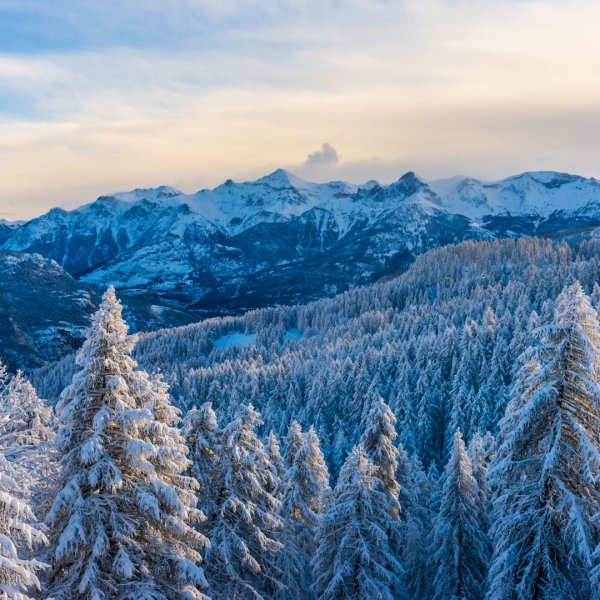 Winter scenery at Puy Saint Vincent in Briançon, France, showcasing a stunning snowy mountain range, and outdoor enthusiasts enjoying winter sports.