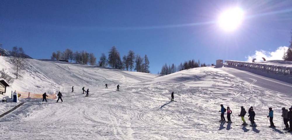 Birkenlift in Austria - a group of people skiing down a snow covered slope.