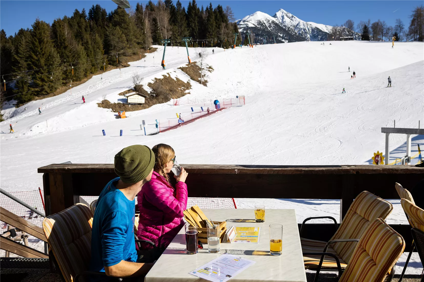 Birkenlift in Austria - two people sitting at a table in the snow.