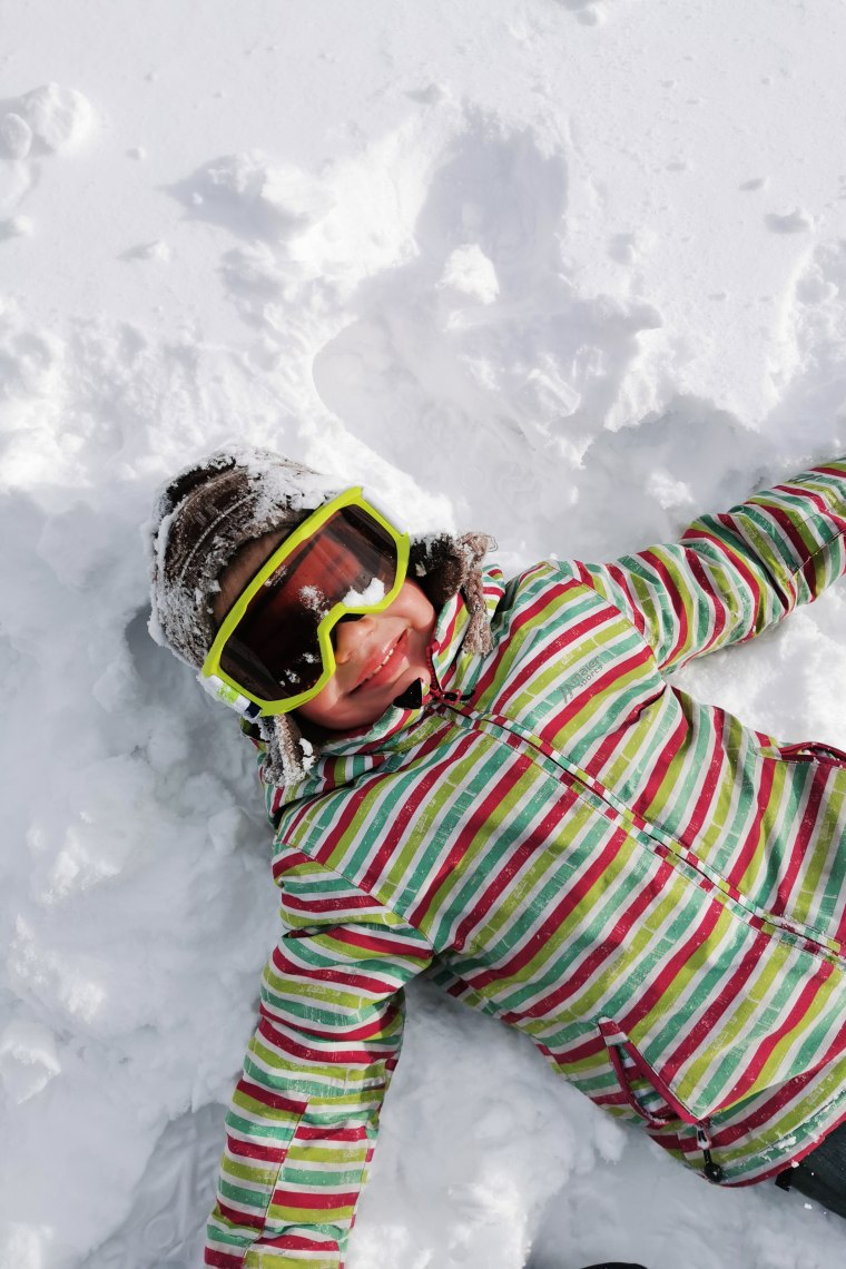 Wexl Arena – St Corona am Wechsel in Austria - a child laying in the snow wearing goggles.